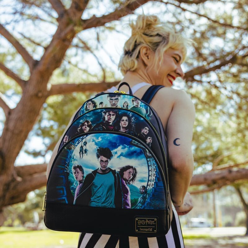 Woman wearing the Harry Potter Movie Posters Triple Pocket Backpack outside with trees in the background
